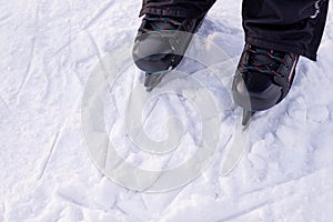 Man's hockey skates on ice background. People skate on the rink. Weekend entertainment in the winter outdoors