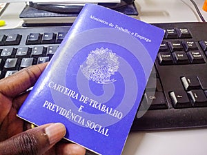 Man`s holding Brazilian document work and social security with a keyboard in the background