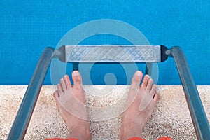 Man's legs and ladder near the pool