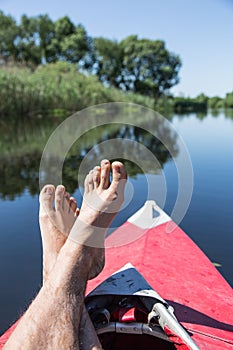Man's legs over canoe.