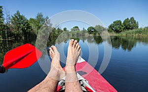 Man's legs over canoe.