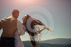 Man`s love. Man hug woman with flying long hair on sunny day