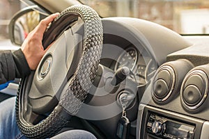 Man`s male hand of the driver on the steering wheel of the car