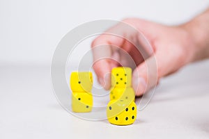 Man`s Mans Hand Lining up Holding Yellow Dice