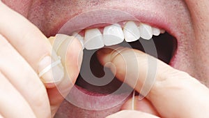 a man's mouth close-up. a man brush your teeth with dental floss.