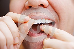 a man's mouth close-up. a man brush your teeth with dental floss.