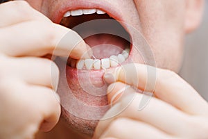 a man's mouth close-up. a man brush your teeth with dental floss.