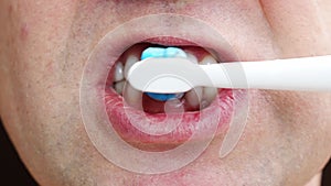 a man's mouth close-up. a man brush your teeth withtoothbrush and toothpaste