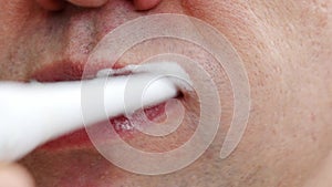 a man's mouth close-up. a man brush your teeth withtoothbrush and toothpaste