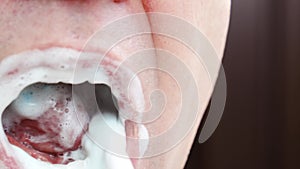 a man's mouth close-up. a man brush your teeth withtoothbrush and toothpaste