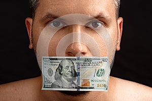 The man`s mouth is sealed with dollars, money. The concept of buying silence, corruption, lobbyists for money