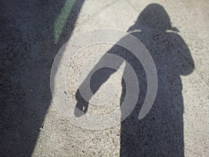 Ma`s shadow on grey colored floor photo