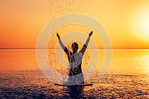 Man`s silhouette in calm water at sunset