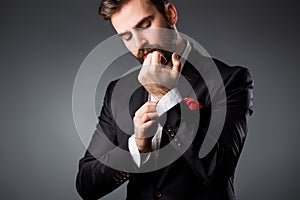 Man's style. Elegant young man getting ready. Dressing suit, shirt and cuffs