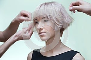 Man's stylist's hands making hairstyle