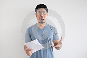 Man is sad and shocked by the letter in his hand on isolated background.