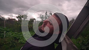 A Man Is Sad on the Street in Cloudy Weather, Looking into the Void. Bearded and Serious Man