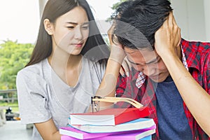 Man sad student checking a failed exam sitting together at table