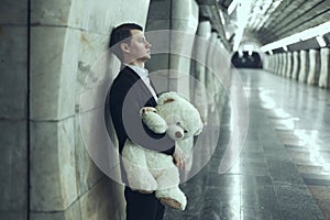 Man is sad with a teddy bear toy in his hands.