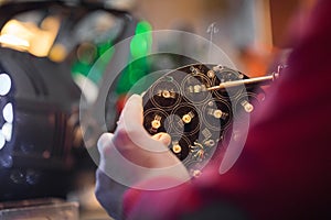 Man with safety glasses repairing motheboard with soldering iron