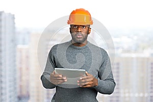 Man in safety helmet and computer tablet.