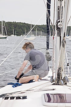 Man on sailboat tying a rope