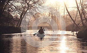 A man sailing the river during a peaceful evening sunset