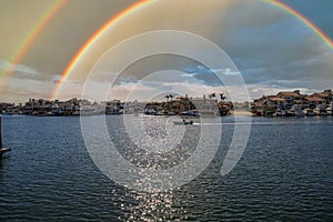 A man sailing a small motor boat at Huntington Harbour with boats and yachts docked in Huntington Harbour and homes