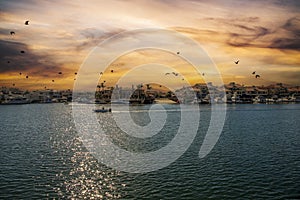 A man sailing a small motor boat at Huntington Harbour with boats and yachts docked in Huntington Harbour and homes