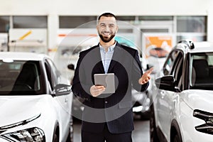 Man Sales Manager Holding Tablet in Car Showroom