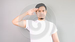 A man in salute pose and serious face.