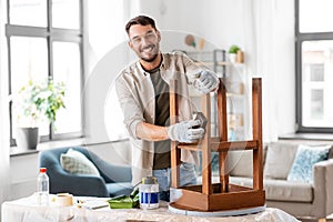 man sanding old round wooden table with sponge