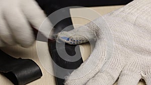 A man is sanding a puncture site in a bicycle tube. For gluing. Close-up shot