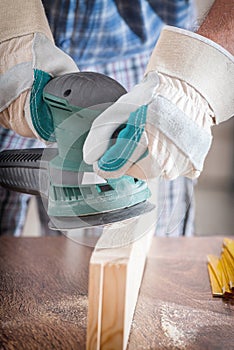 Man sanding a wood with orbital sander