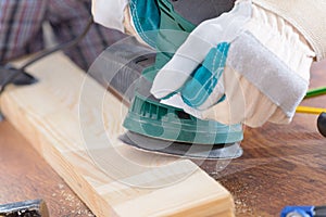 Man sanding a wood with orbital sander