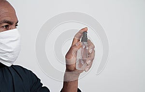 Man with sanitising spray bottle beating the coronavirus stock photo