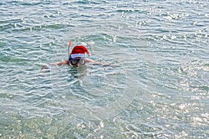 Man in a Santa Claus hat and diving mask, Christmas background with copy space. Relax in tropical countries in the winter, New