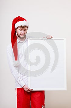 Man in santa hat with blank banner. Copy space