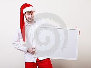 Man in santa hat with blank banner. Copy space.