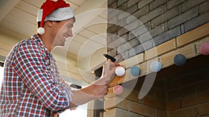 Man in Santa hat fireplace in house with Christmas lights