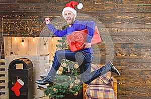 Man santa hat hurry to deliver gift on time. Spread happiness and joy. Bearded guy in motion jump. Delivery christmas