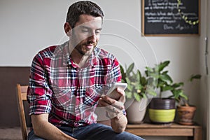 Man sat on chair using mobile phone