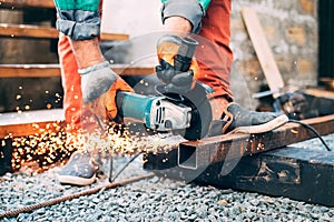 A man is sawing metal with an angle grinder