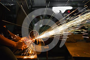 Man sawing metal by grinder