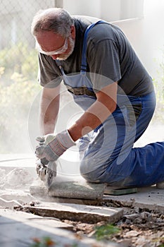 Man sawing stone with grinder