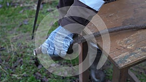 a man saws a dry tree branch with a hand saw