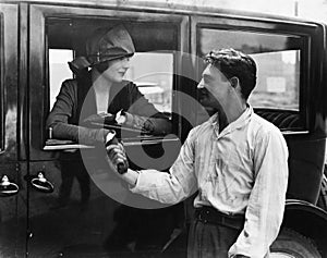 Man saying goodbye to woman in car