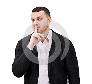 Man saying hush and be quiet with finger on lips gesture looking at camera, isolated on white background