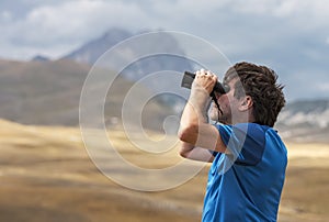 Man scanning the sky with binoculars