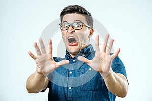 Man with scared expression on his face making frightened gesture